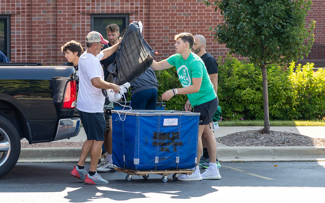 WOW volunteers helping students unload their vehicles